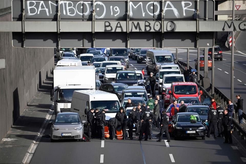 Policias retiran a ambientalistas que bloqueaban el tráfico en la autopista A100 de Berlin.