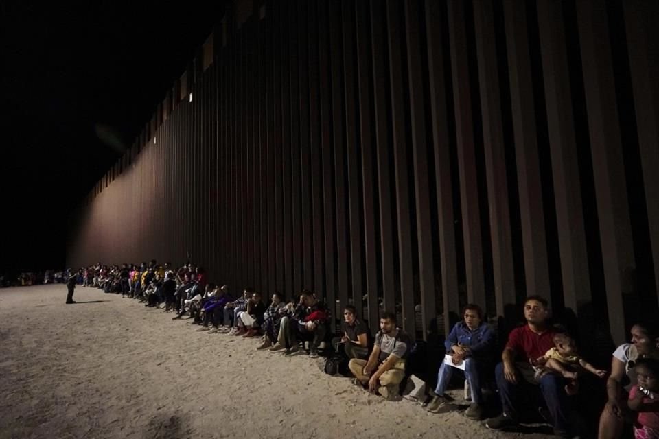 Migrantes esperan a un lado del muro migratorio entre México y Estados Unidos, el 23 de agosto del 2022.