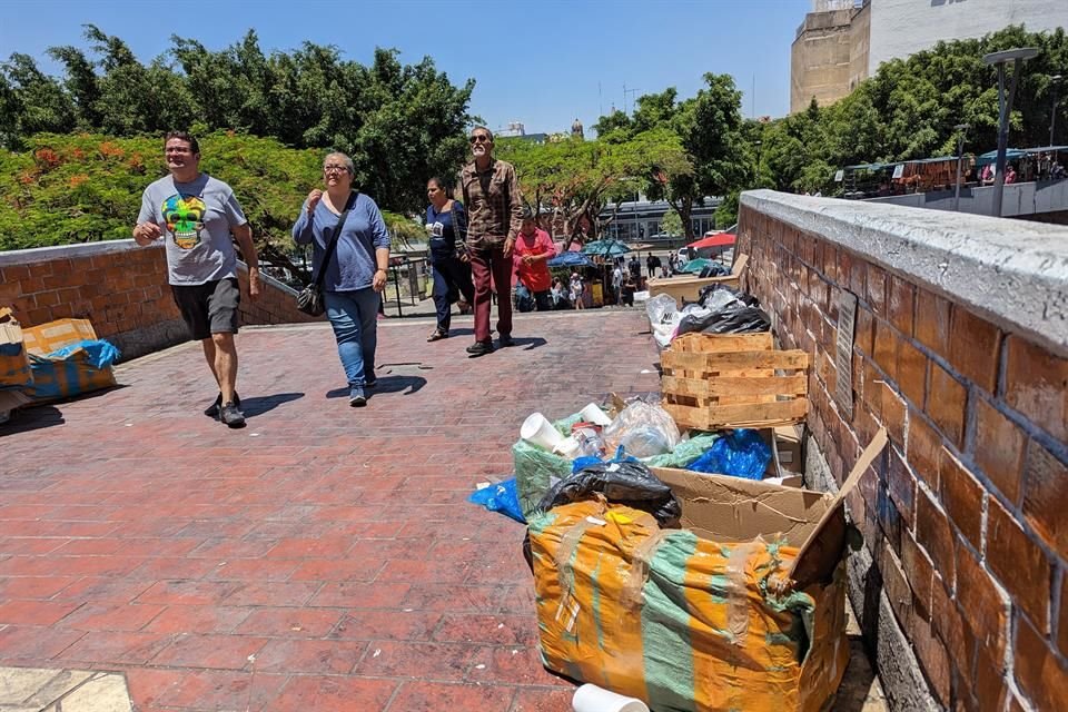 En los pasillos aledaños al Mercado San Juan de Dios hay montones de basura, entre los que pasa la gente.