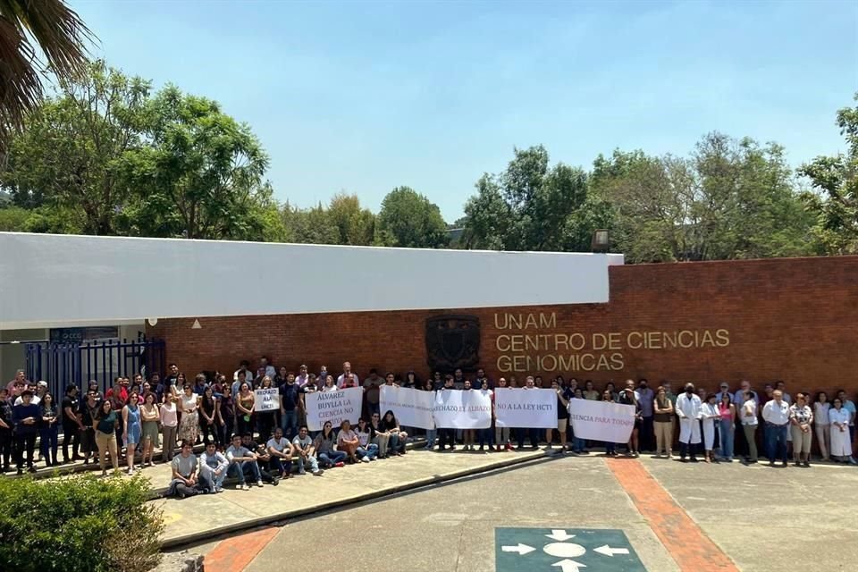 Integrantes de la comunidad del Centro de Ciencias Genómicas de la UNAM realizan una concentración con pancartas con leyendas como 'Álvarez-Buylla la ciencia no es tuya'.