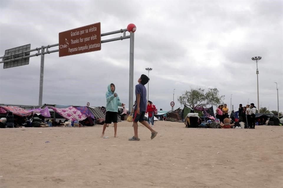 Migrantes venezolanos esperan información para ingresar a Perú, en Arica, en la frontera entre Chile y Perú.