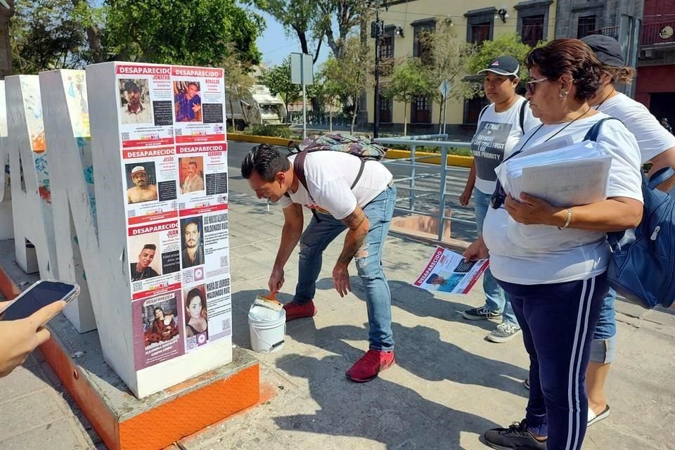 En bolardos y letras turísticas del Centro zapopano, el Colectivo Luz de Esperanza realizó una pega de fichas con rostros de desaparecidos.