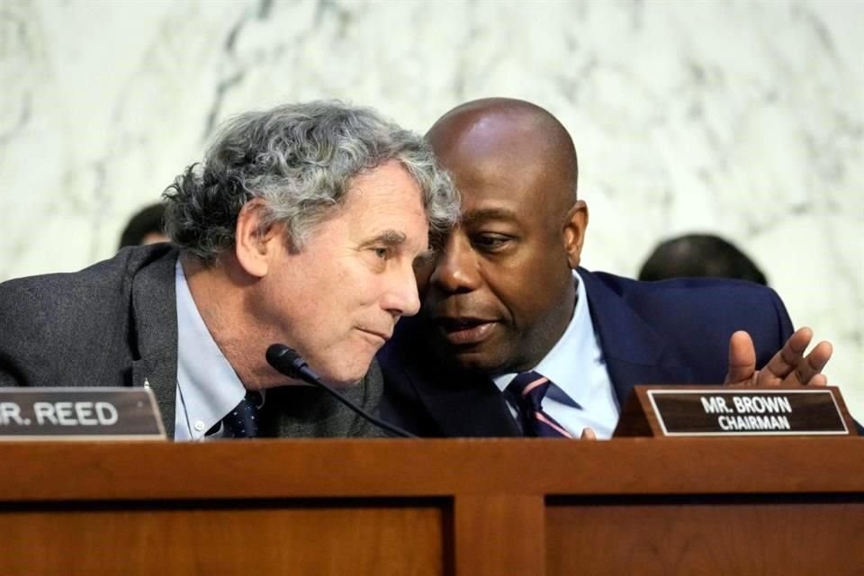 El presidente del comité, el Senador Sherrod Brown, conversa con el miembro de mayor rango, el Senador Tim Scott.