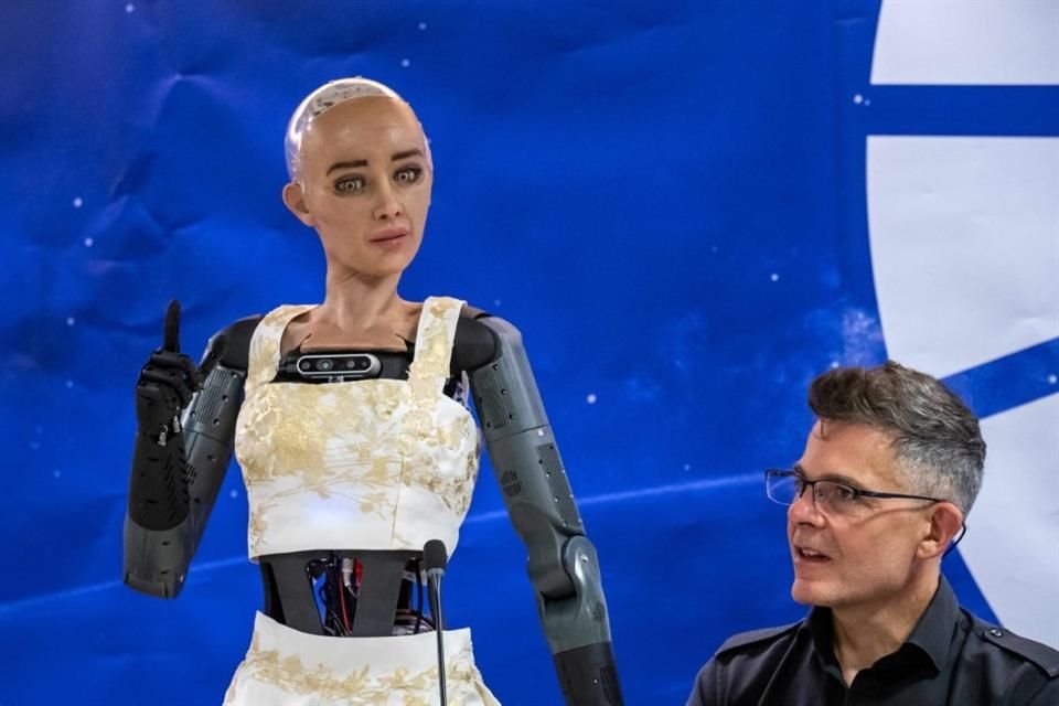 Hanson Robotics CEO David Hanson (R) listens to AI robot 'Sophia' during what was presented as the World's first press conference with a panel of AI-enabled humanoid social robots.