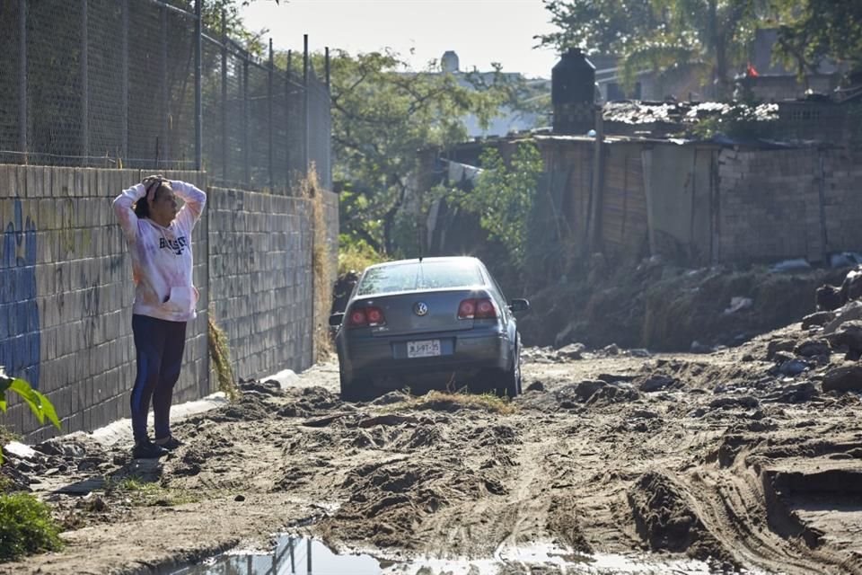 Un automóvil quedo atascado en el lodo, a consecuencia del arrastre de piedras, troncos, ramas y arena de una corriente que baja del Bosque La Primavera.