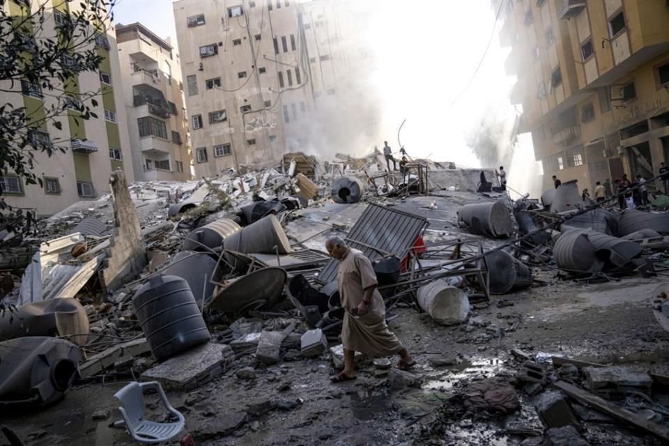 Los palestinos inspeccionan los escombros de un edificio después de que fue alcanzado por un ataque aéreo israelí.