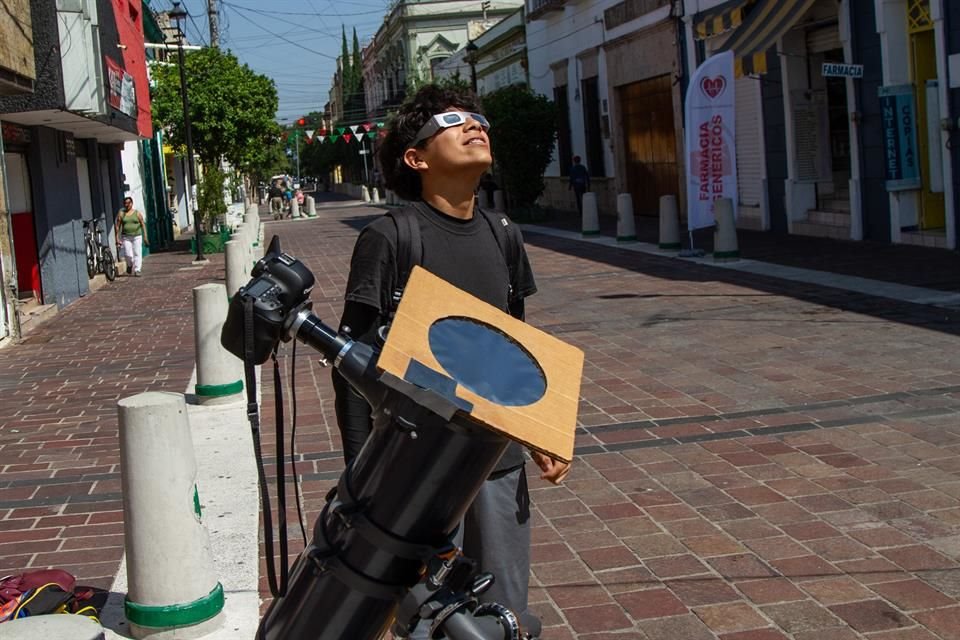 Paseantes observan el eclipse en la calle Pedro Loza.