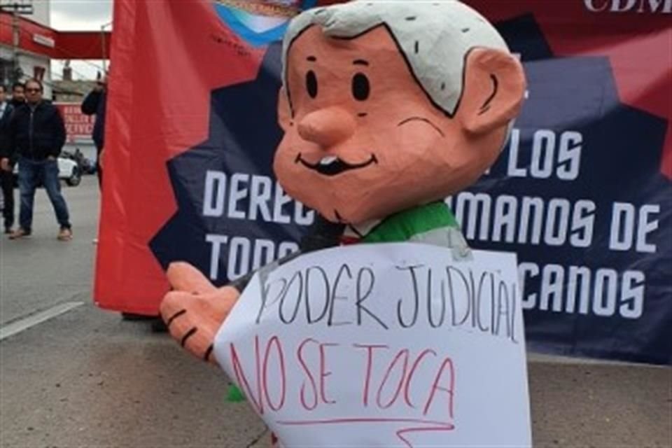 Una figura del Presidente es exhibida durante la protesta de trabajadores del PJF en Avenida Revolución.