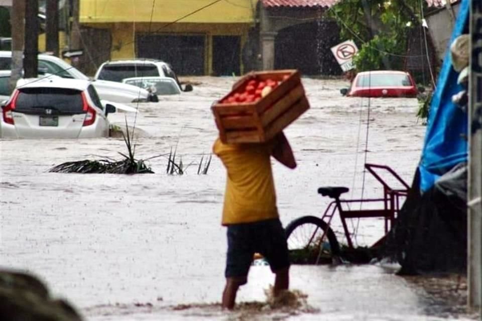 Ciudadanos difunden fotografías de ciudadanos tratando de sacar sus pertenencias y mercancía en Coyuca de Benítez.