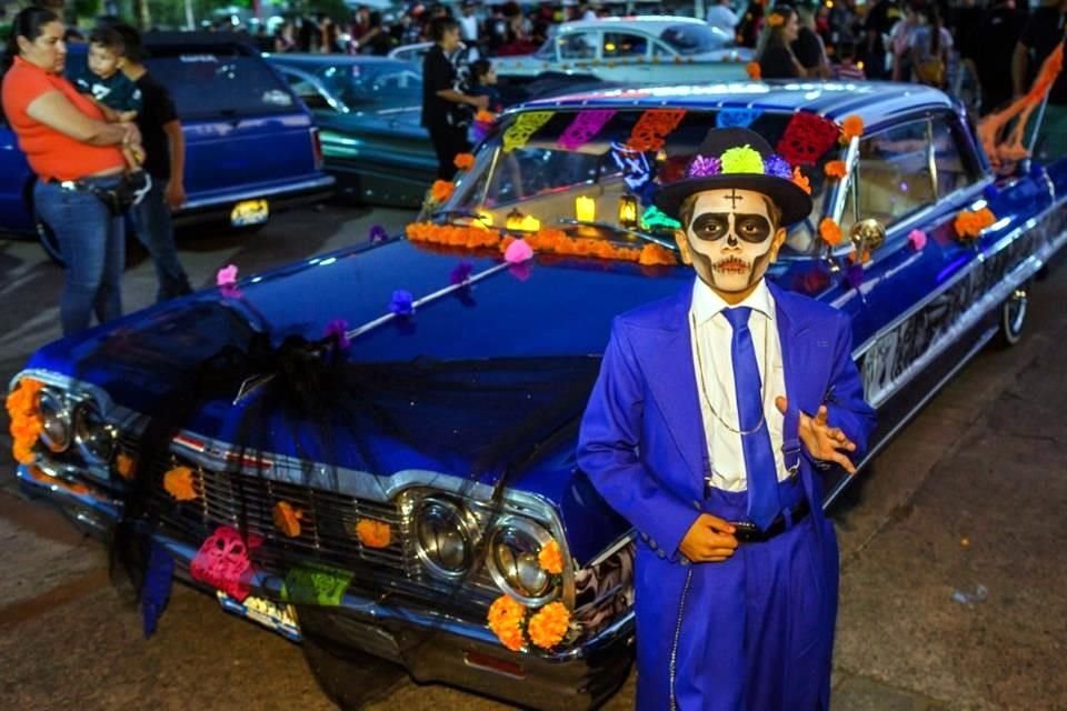 Un catrín pachuco posa en el coche decorado Chevrolet Impala 64. 
