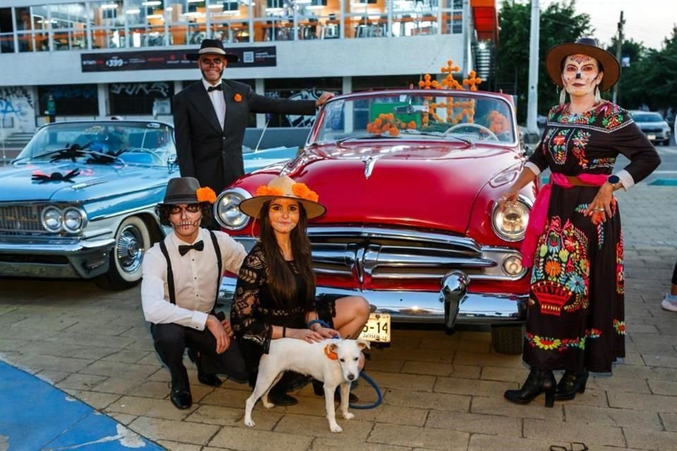 Familia Magallanes pintados como catrinas y catrines a un lado de su auto clásico participan en la celebración.