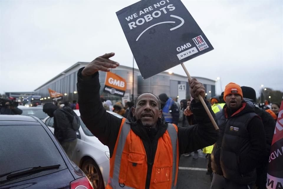 An Amazon staff member gestures on a GMB union picket line, outside the online retailer's site as workers take part in a strike in their long-running dis