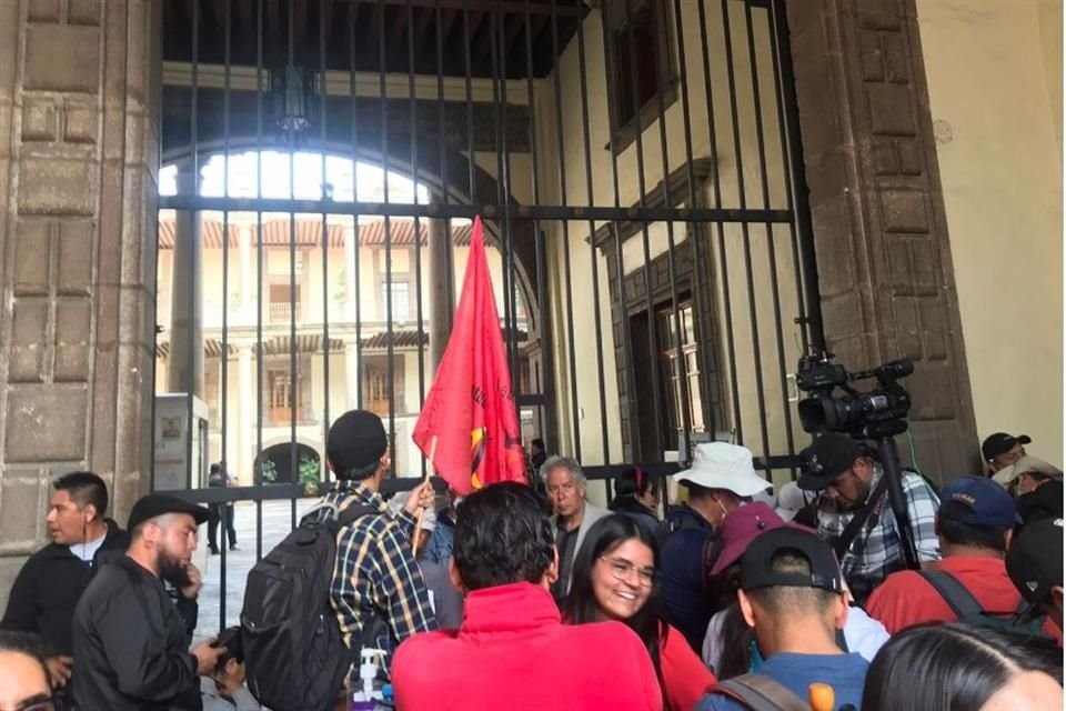 En la recepción, los docentes se toparon con una reja metálica cerrada con una cadena, misma que comenzaron a agitar con fuerza, pero no la derribaron ni pasaron.