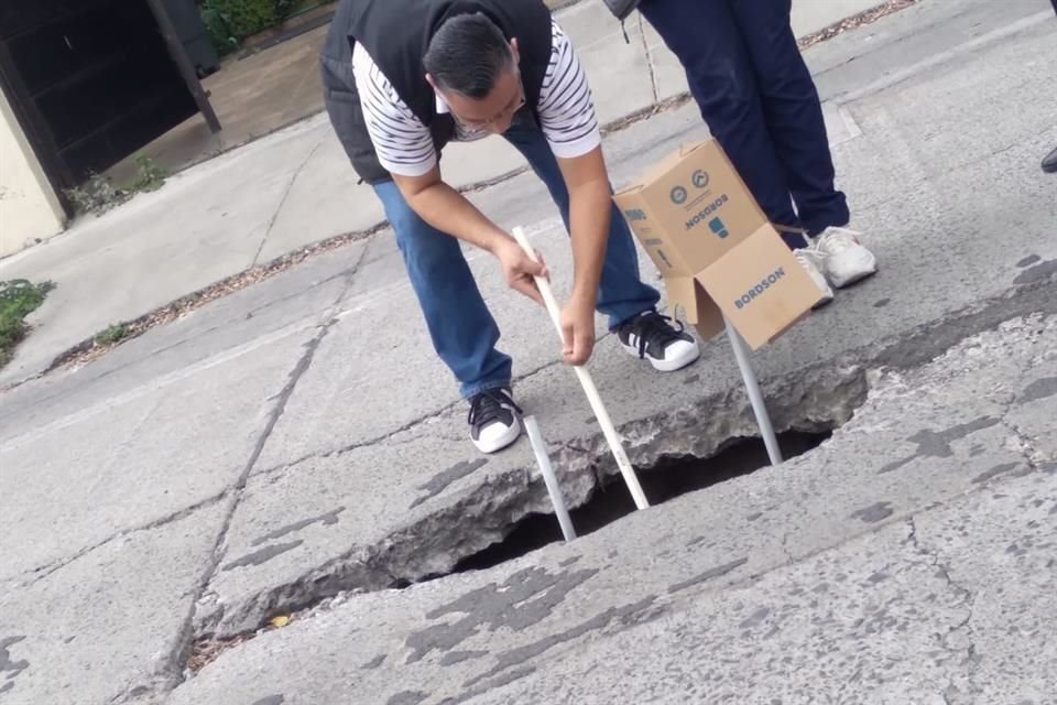Vecinos de la colonia han colocado tubos y cartón para prevenir a transeúntes y condecores del socavón.