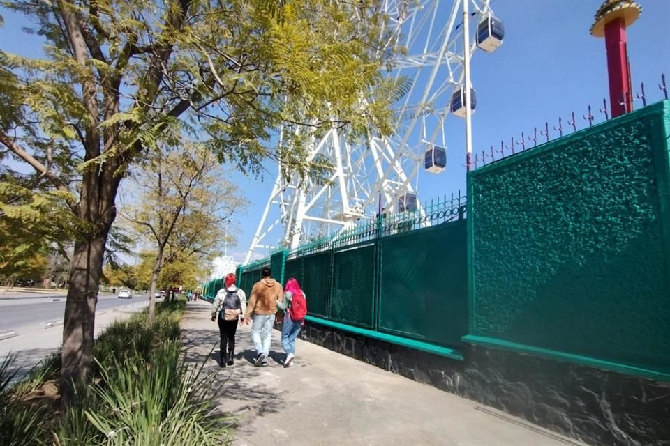 Visitantes que acuden por ver la rueda de la fortuna prendida por las noches, con la idea de que ya está abierto el parque.