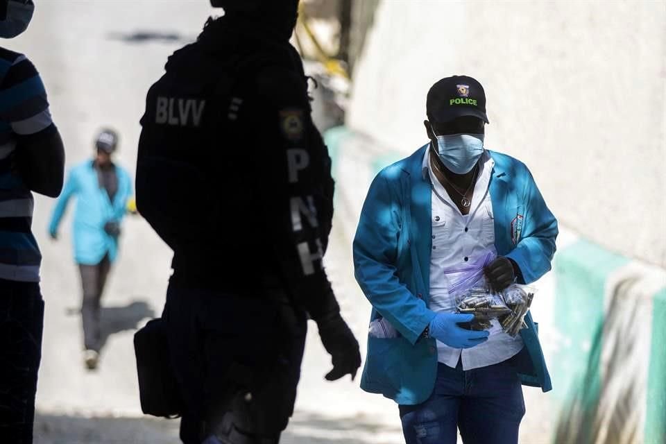 Un investigador forense recolecta los casquillos de bala que fueron disparados en la casa del presidente Jovenel Moise.