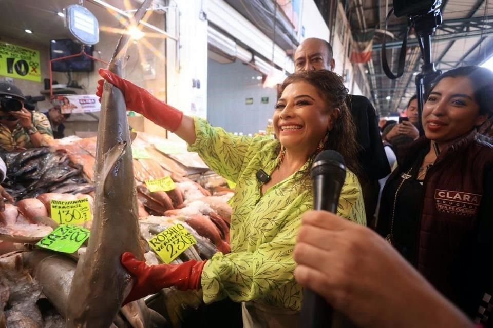 La fotografía con un pescado a todo lo largo es ya un clásico de los recorridos electorales en La Nueva Viga.