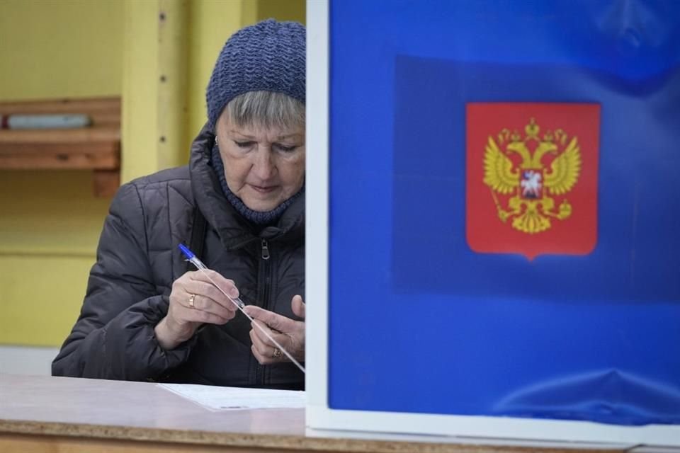 Una mujer comprueba si un bolígrafo escribe antes de rellenar su boleta para las elecciones presidenciales, en San Petersburgo, Rusia, el 15 de marzo de 2024.