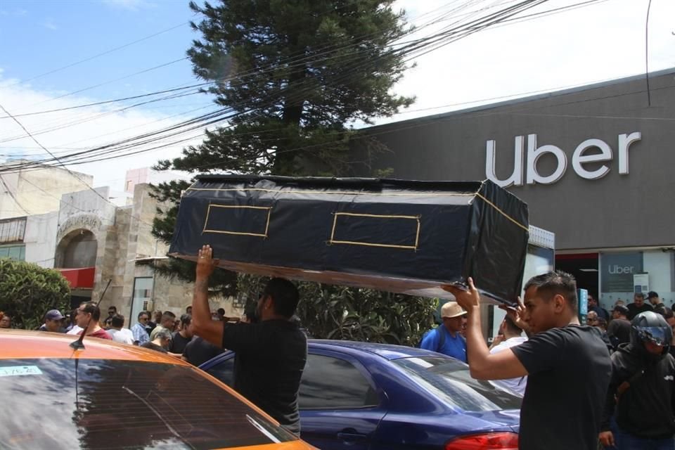 Los conductores cargan un ataúd simbólico desde las oficinas de la aplicación hasta la Fiscalía del Estado.