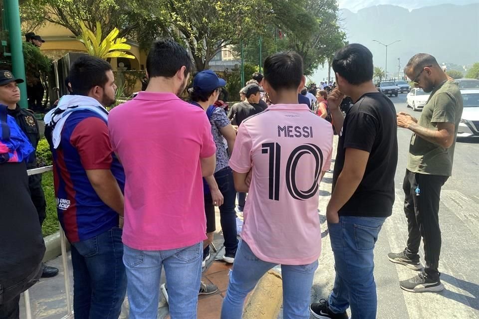 Aficionados con playeras de Lionel Messi aguardan afuera del hotel por el astro argentino.