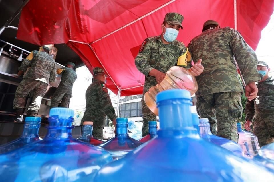 Elementos del ejército proporcionan garrafones a vecinos afectados por agua sucia.