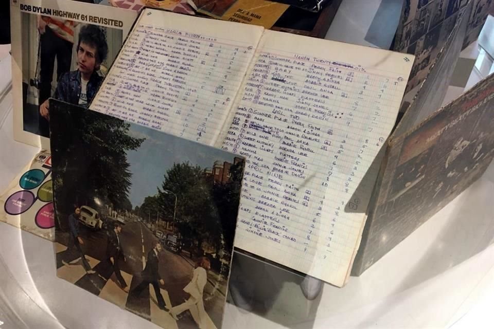 Discos LP de Bob Dylan o The Beatles se exhiben junto con uno de los listados que solía hacer José Agustín tipo las listas de popularidad de Billboard.