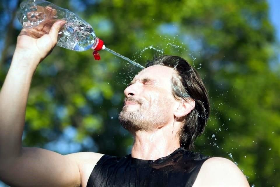 Una de las medidas para cuidarse del calor mientras se hace ejercicio es echarse agua en la cabeza para que escurra.