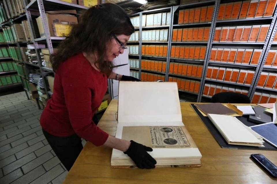 Carmen Pedraza, encargada del Centro Documental de las Artes de Jalisco en el Patio de los Ángeles muestra los carteles del Teatro Degollado de 1928.