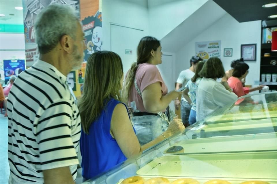 Gran cantidad de gente se acerca a un negocio de donas, para hacer valida su promoción por haber  votado.