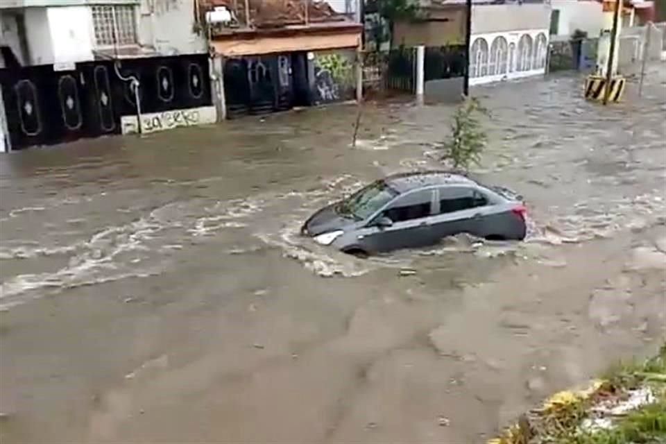 Vehículo arrastrado por la corriente en la lateral del Periférico.