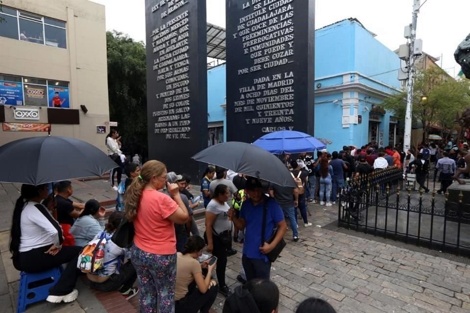 En la espera, algunas personas llevan sombrillas y hasta sillas.