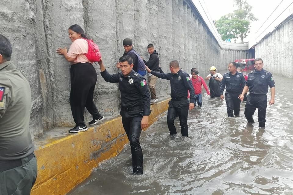 Policías ayudaron a pasajeros a salir del paso a desnivel.