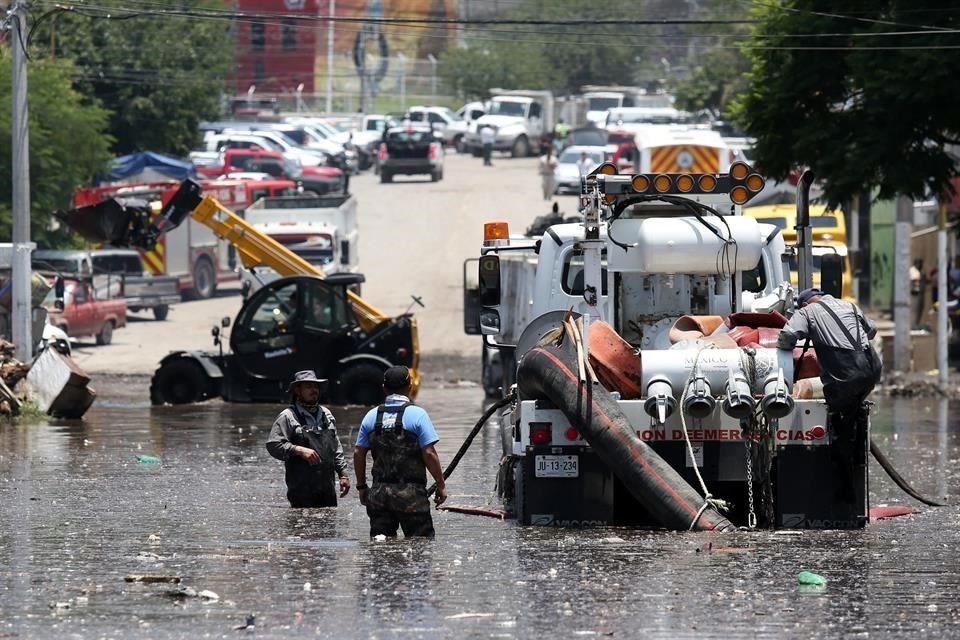 Vecinos junto con personal de Protección Civil trabajan en retirar los escombros y lodo que dejó el desbordamiento del arroyo El Seco.