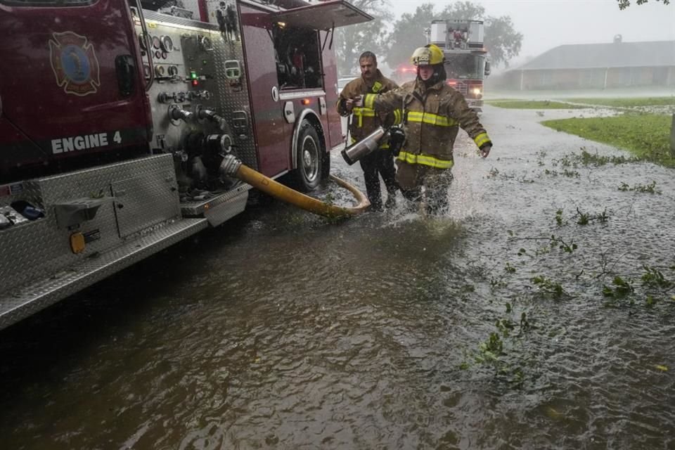 Bomberos de Morgan City caminan por una calle inundada por las lluvias en Morgan City, Luisiana, el 11 de septiembre.