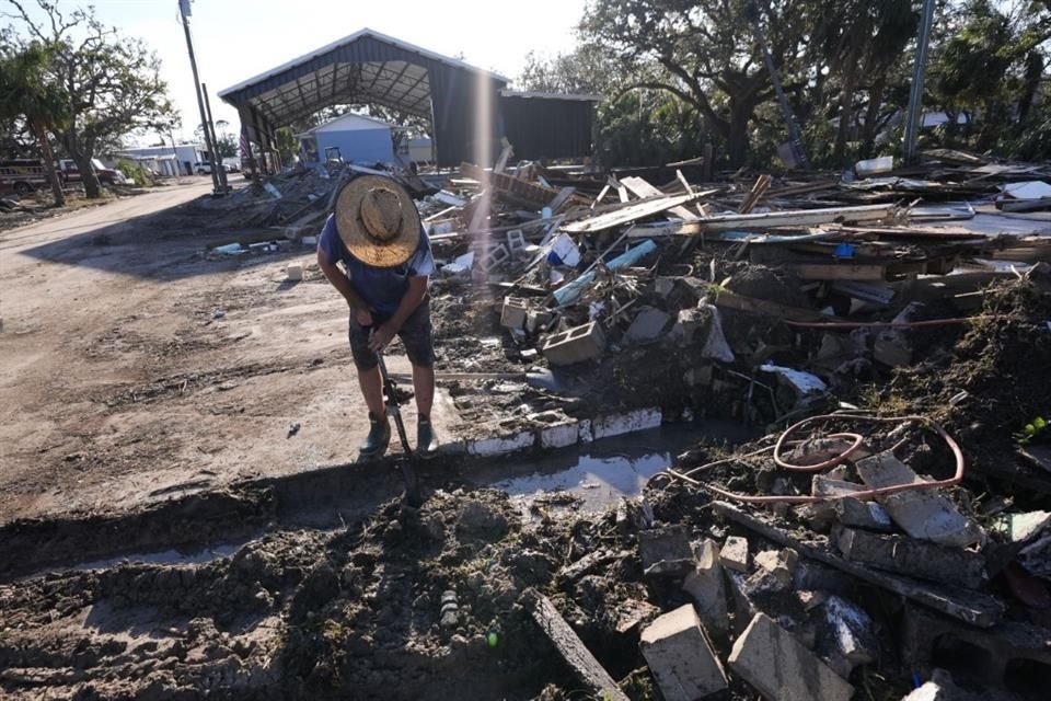 Un hombre busca entre los escombros tras el paso del huracán 'Helene' en Florida.