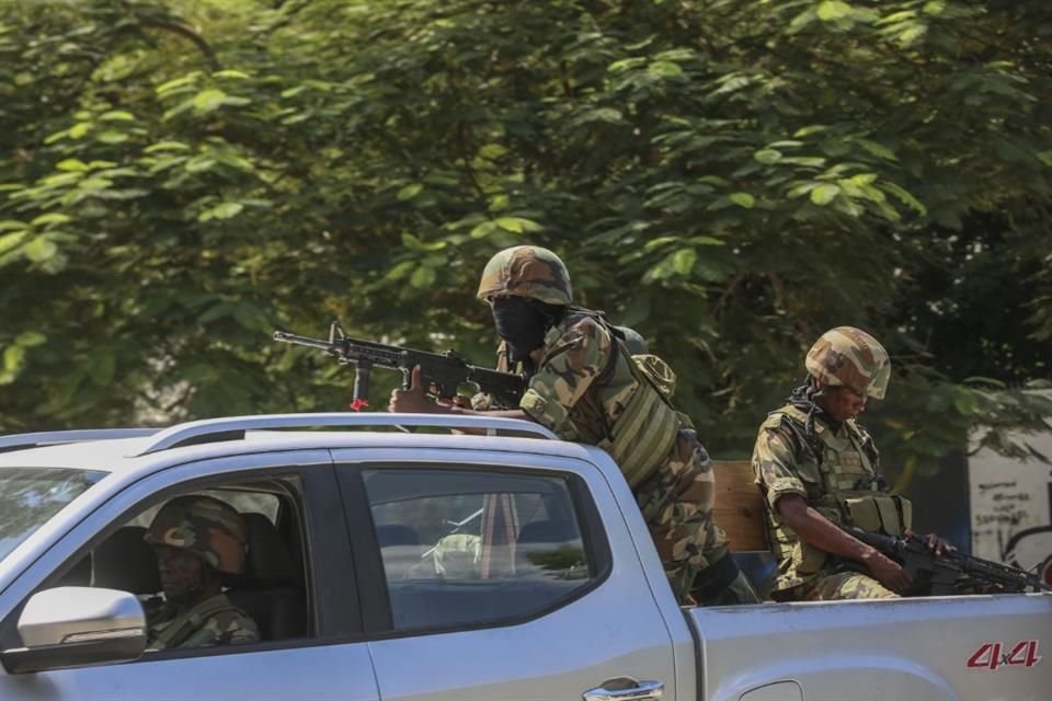 Varios soldados patrullan entre el sonido de los disparos que se oyen a la distancia, en Puerto Príncipe, Haití, el 17 de octubre de 2024.