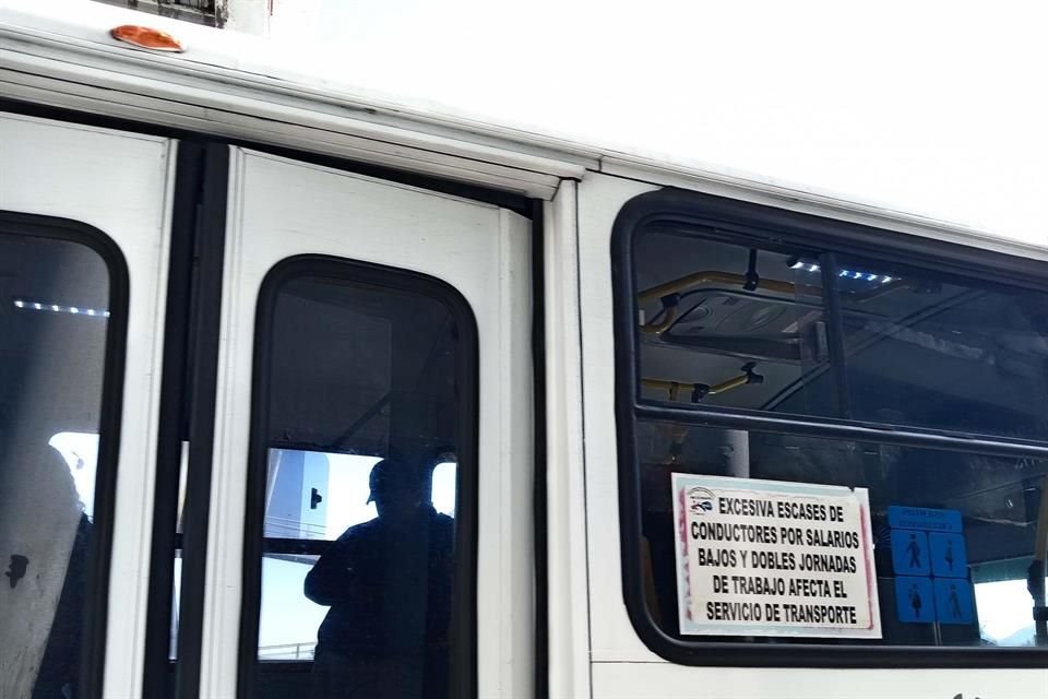 Choferes de la ruta alimentadora A04 de Mi Macro Periférico trabajan bajo protesta con letreros en los autobuses.