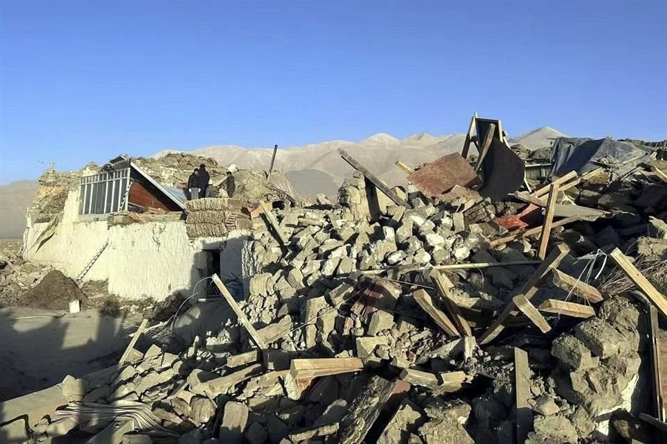 Personas en medio de casas dañadas después de un terremoto en la aldea de Tonglai, región autónoma del Tíbet, en el suroeste de China.