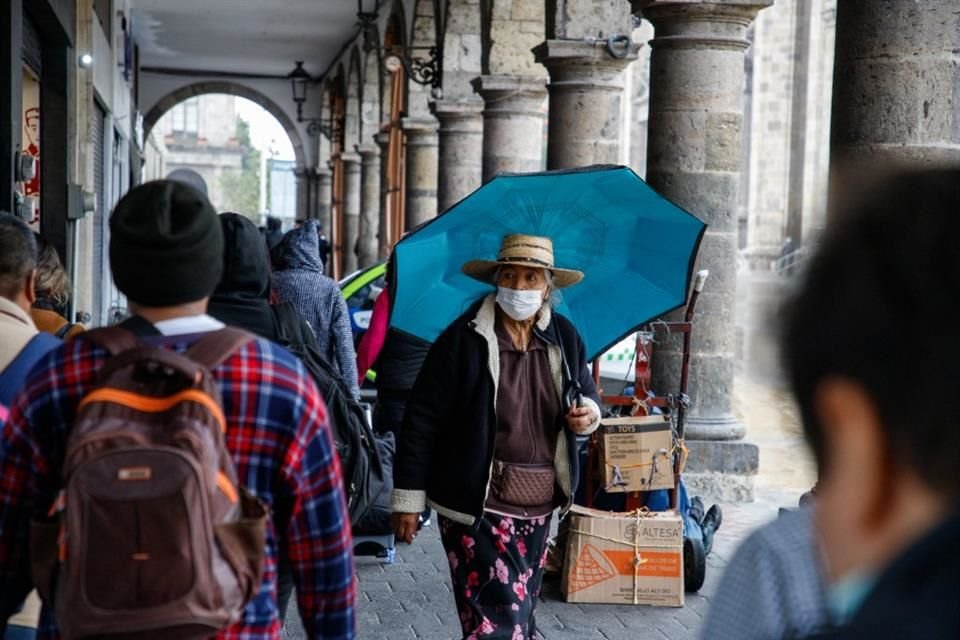 Los tapatíos se previenen de la lluvia y el frío, con ropa abrigadora y paraguas.