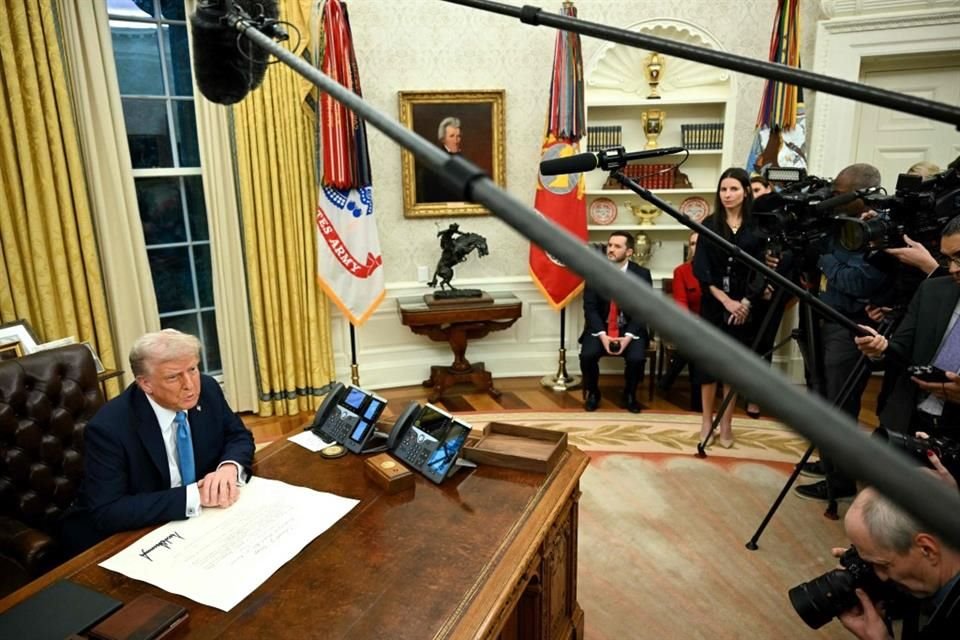 Trump habla con la prensa antes de firmar una orden ejecutiva en la Casa Blanca.