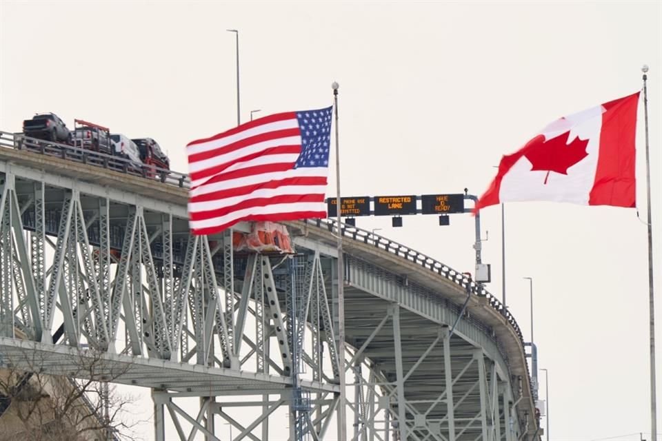 La bandera de EU y la de Canadá vistos a un costado del río St. Clair.