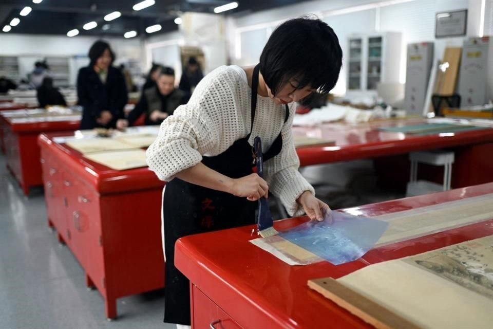 Documentos y pergaminos son colocados en bastidores especiales para su limpieza en el taller del museo de la Ciudad Prohibida, que este año arriba a su centenario.