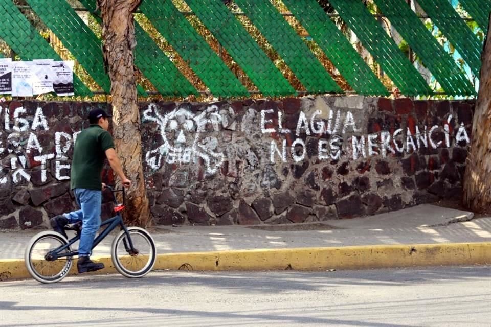 Integrantes de la Asamblea Tlalpan-Coyoacán reclaman con pintas en el exterior del pozo.