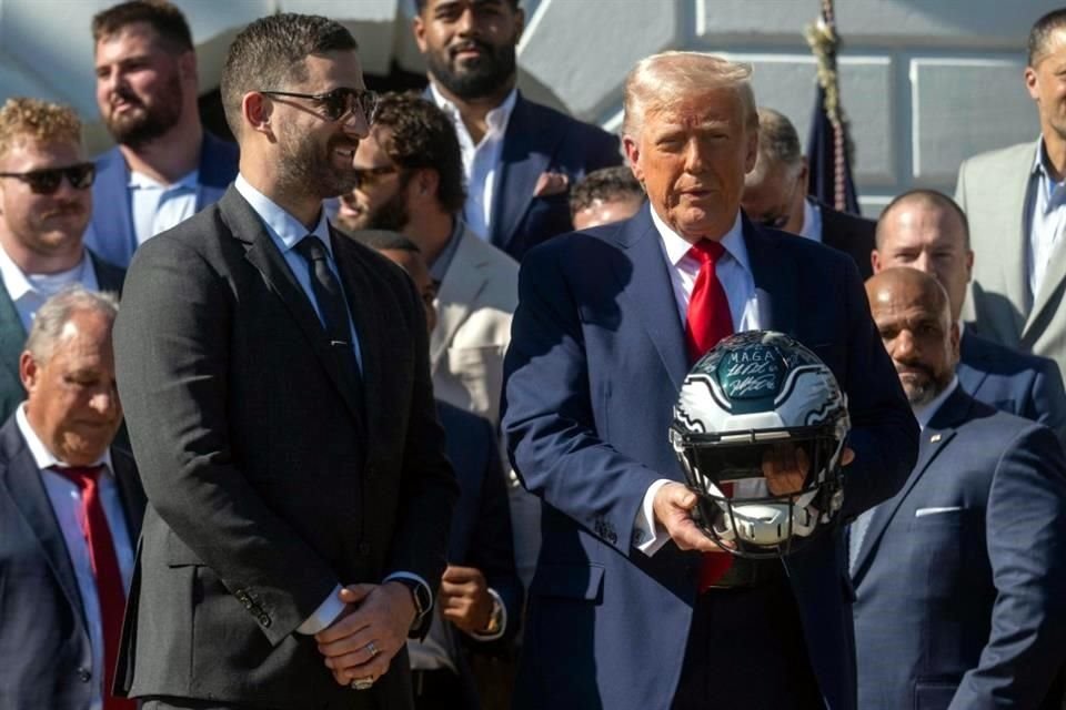 El head coach Nick Sirianni posando al lado de Donald Trump, quien carga un casco del conjunto de Philadelphia.