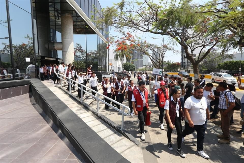 Los trabajadores del SAT de Avenida Américas desalojan las instalaciones para participar en el simulacro de sismo.