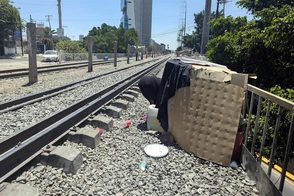 Junto a la vía se observan casas construidas con lonas, cajas y palos.