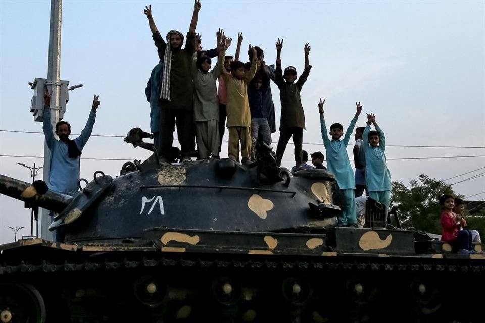 Paquistaníes hacen señales de victoria junto a un tanque mientras celebran el alto el fuego entre Pakistán y la India.