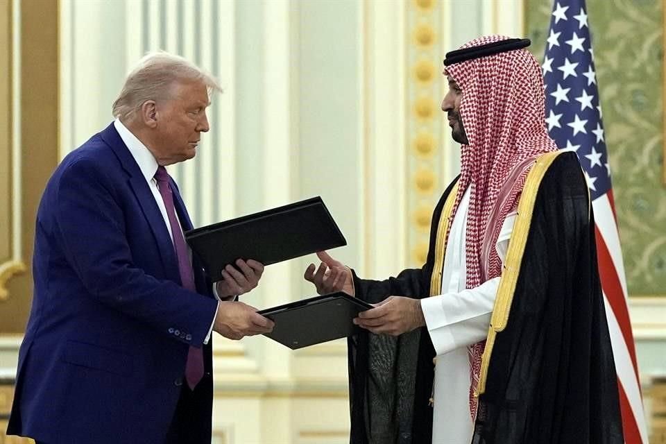El Presidente Donald Trump y el príncipe heredero saudí, Mohammed bin Salman, intercambian documentos durante una ceremonia de firma en el Palacio Real.