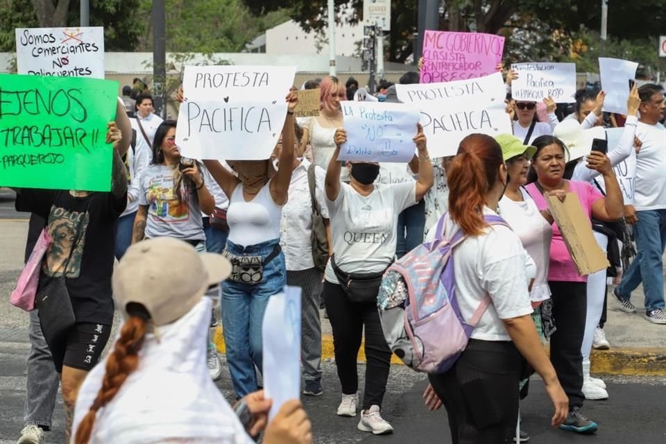 De manera pacífica un grupo de comerciantes del parque Rojo se manifiesta, parados en el semáforo durante luz roja  mostrando su pancartas.