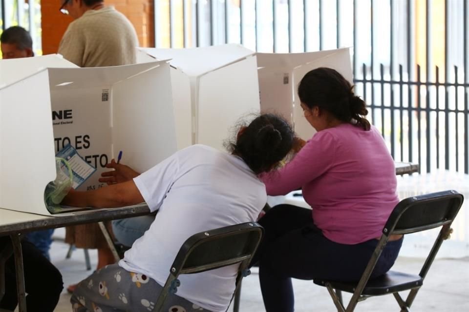Como en la escuela, esta persona se asoma a la casilla de su derecha, buscando ver y entender un poco mejor cómo se realiza la votación.